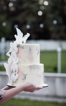 close-up of hands with a wedding cake