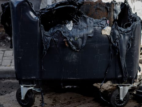 Melted trash can from fire. Burned trash in waste container in the city 