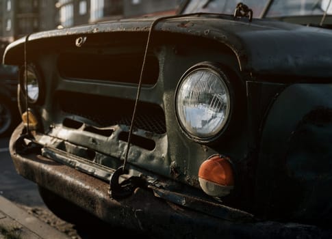 Details of the front headlights of an old car. Antique automobile with rust.