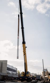 yellow wheeled truck crane stands on construction site . Heavy wheeled loading equipment.