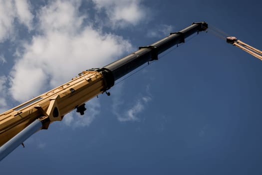 Mobile truck crane boom above blue sky