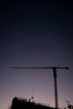 silhouettes of construction at sunset. tower cranes in the dark