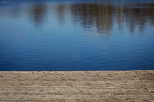 Wooden pier with blue sea and water background
