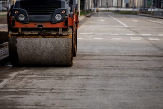 Road construction works with steamroller machine and asphalt finisher. copy space