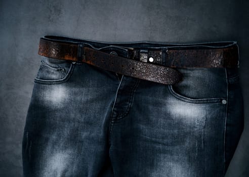 part of black fashion men's jeans with a leather belt. urban style