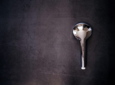 Silver stainless steel shower head on a dark background. copy space