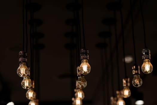 Many elegant lamps bulbs hanging on ceiling