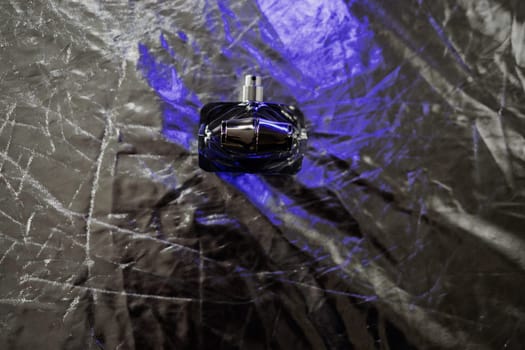 Fashion perfume in glass bottle on silver background. Passionate perfume. 