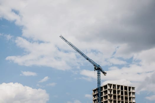 Inside place for tall buildings under construction and crane under a blue sky