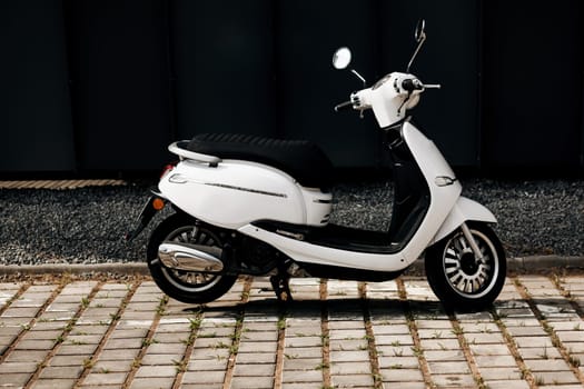 View of traditional white vintage moped on street in Europe