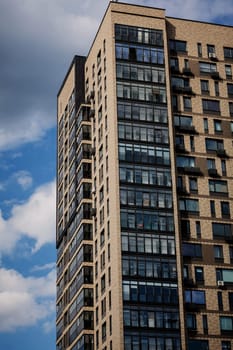 New brick of modern apartments with balconies and blue sky in the background