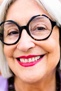 close-up portrait of a beautiful senior woman smiling happy looking at camera, concept of elderly people happiness and active lifestyle