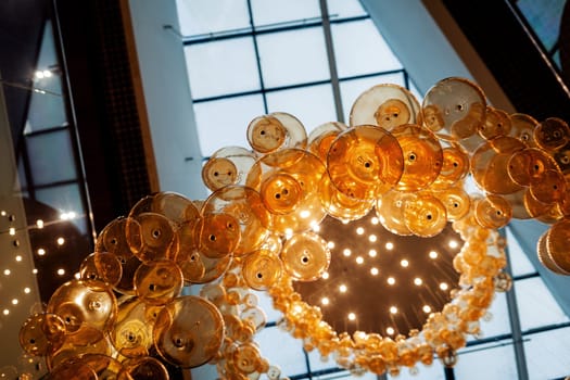 Many large glass lamps hang from the ceiling of the mall