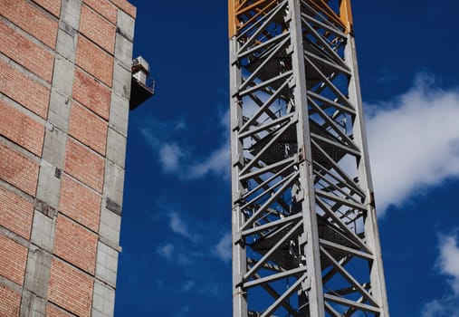 tower crane and a new building under construction against the blue sky