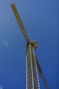 Industrial construction crane over blue sky on sunrise