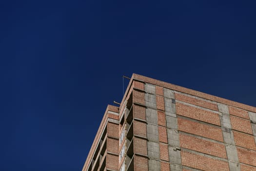 new unfinished brick building against the blue sky