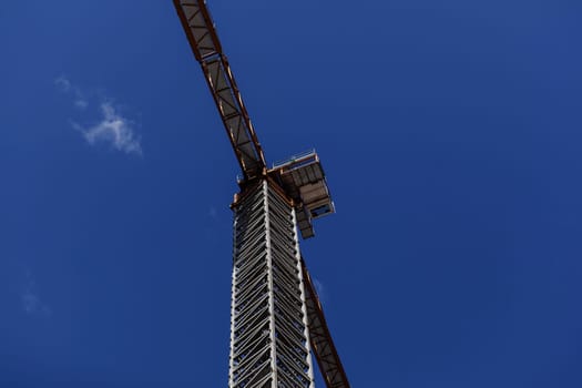 tower crane on the background of the blue sky . Industrial scene