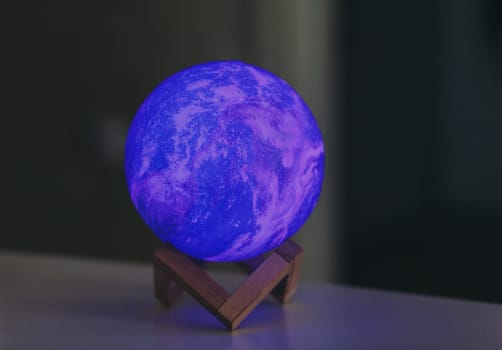 moon-shaped night light on a stand. neon glow