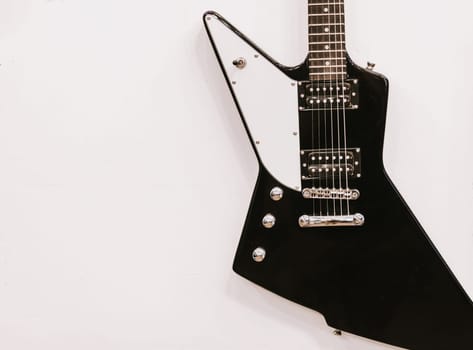 Black and white guitar hanging on the wall. Copy space