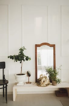 Stylish design home interior of living room with wooden commode, mirror, armchair, and elegant accessories. Classic home decor.