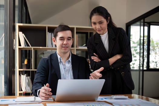 Team business of diverse partner business woman discuss project on laptop sitting at table in office. Two colleague of professional business people working together.