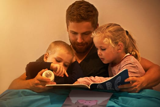 Night, kids or dad reading book in home for learning, education or storytelling in bedroom for care. Family, relax or father with children siblings for a fantasy with a girl, boy or support for love.