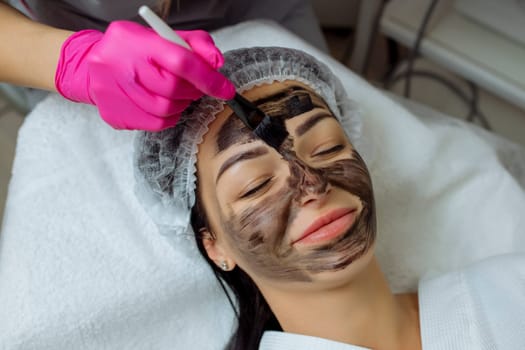 Close-up of carbon peeling procedure for middle-aged woman face. Laser pulses clean skin. Process of photothermolysis, warming, laser carbon peeling. Facial skin rejuvenation, cosmetology treatment