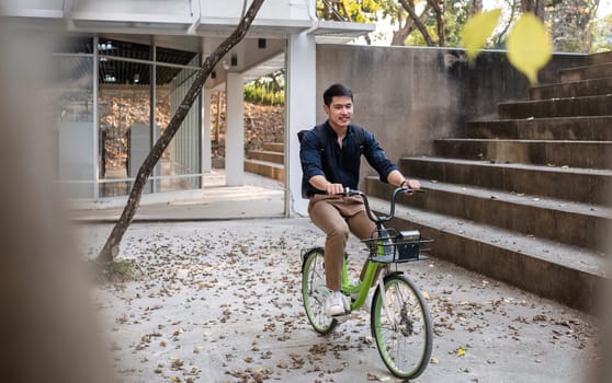 Young Asian businessman Go to work by cycling to reduce air pollution and stay healthy..