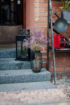 entrance to the cafe is decorated with vintage elements - a vase with flowers.