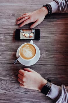 hipster man in a cafe. close-up of hands with a cappuccino cup. personal blog