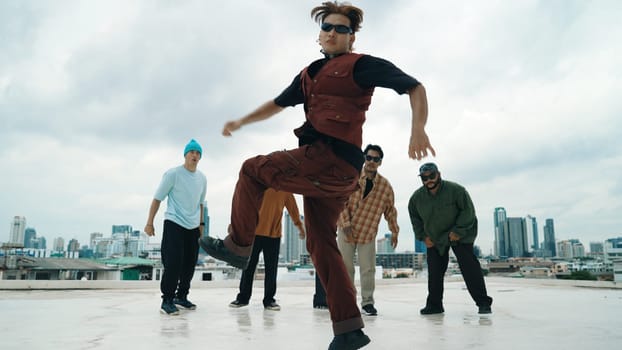 Professional asian street dancer practice B boy dance while multicultural friends at roof top. Young modern dancing group doing hip hop movement. Style,fashion,action. Outdoor sport 2024. Endeavor.