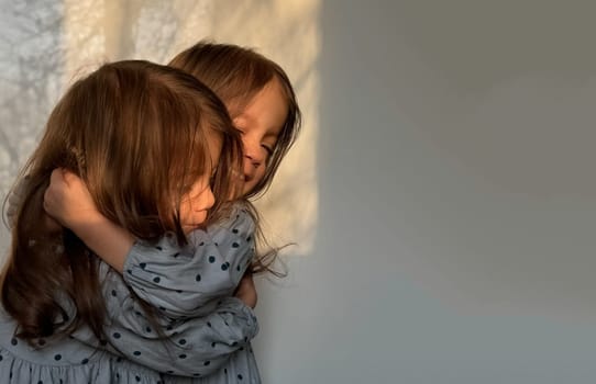 Happy siblings day. Portrait of twin baby girls hugging each other. Copy space.