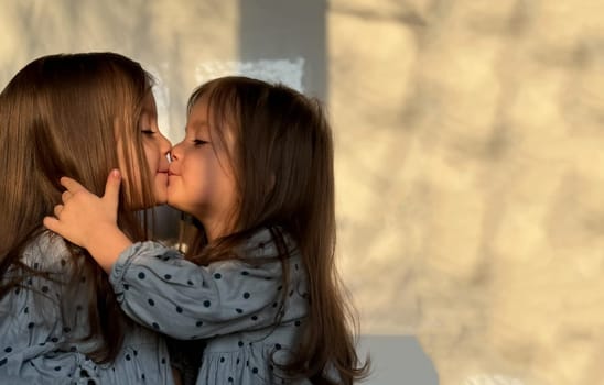 Portrait of mixed race twin baby girls kissing and hugging each other. Happy siblings day