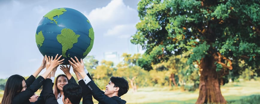 Earth day concept with big Earth globe held by group of asian business people team promoting environmental awareness with environmentally sustainability and ESG principle for brighter future. Gyre