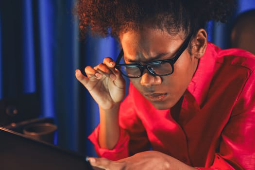 African woman businesswoman or blogger wearing pink shirt with serious face, looking and focusing on screen laptop with struggle project. Concept of stressful expression at work from home. Tastemaker.