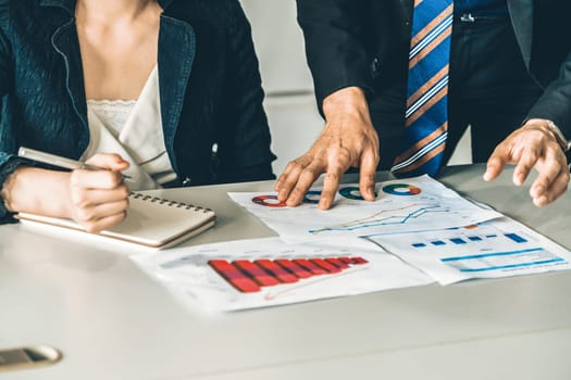 Businessman and businesswoman in meeting working with many financial statement document on desk. Concept of busy business profit analysis and brainstorm. Close up shot at people hands and papers. uds