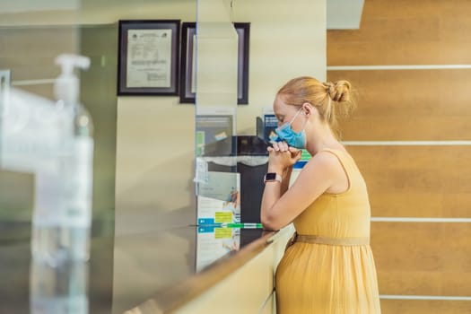 A pregnant woman stands at the hospital reception desk, embarking on a crucial phase of her maternity journey, seeking care and support in a healthcare setting.