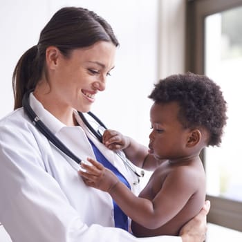 Happy, pediatrician and woman with baby, boy and checkup with stethoscope and doctor in clinic. Medical, professional and employee with healthcare or infant with appointment or medicare with wellness.