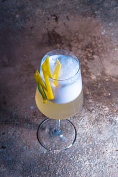 Sophisticated champagne cocktail with lemon twist on wooden table, blue background. Perfect for special occasions and toasting moments.