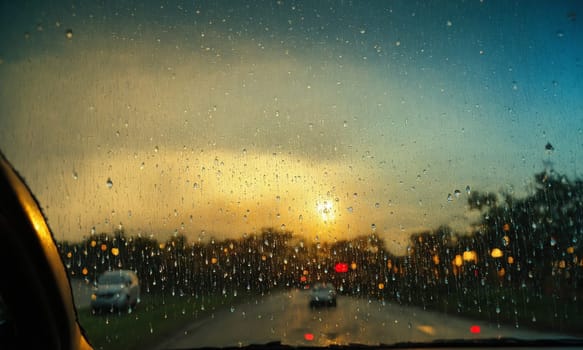 Driving on a rainy day through the windshield of a car