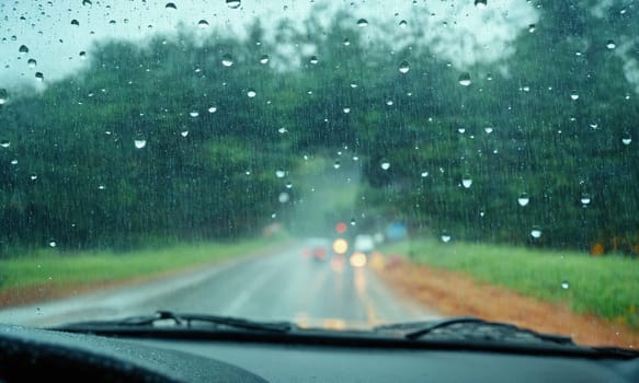 Driving on a rainy day through the windshield of a car