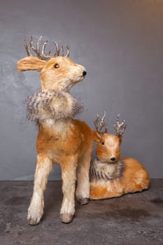 Adorable reindeer figurines with silver antlers, perfect for holiday displays, isolated on gray. Add a festive touch