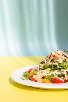 Delicious and healthy salad with greens, cherry tomatoes, and grilled shrimps. Served on a white plate, the image features a clean, modern look. Perfect for stock agencies or as a mockup.