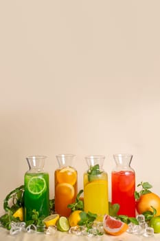 Assorted cold lemonades in glass jugs on an ochre background. photos for the menu.