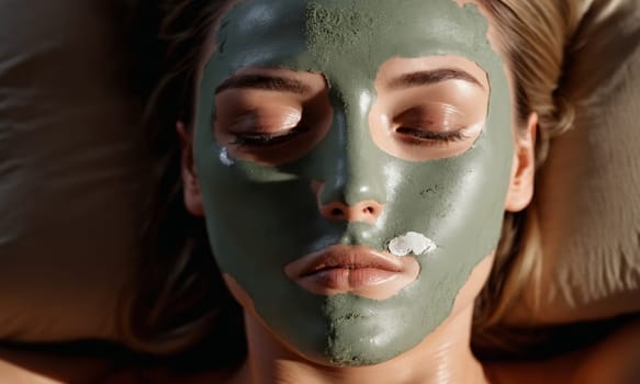 Beautiful young woman with green clay facial mask on her face. Spa treatment