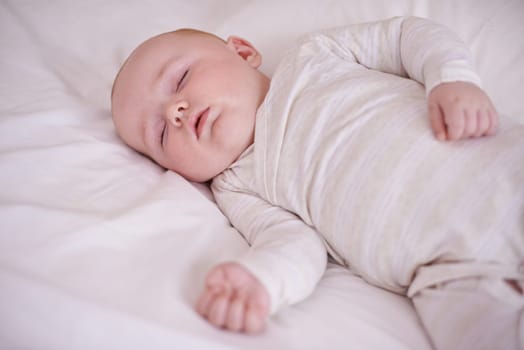 Baby, bed and sleeping in house for relax nap in pajamas for health development growth in nursery, wellbeing or morning. Kid, calm and comfortable youth in apartment for resting, family home or peace.