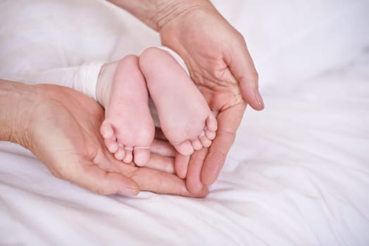 Baby, feet and hands for childcare on bed or development with parenting trust with support, love or connection. Kid, foot and fingers in palm for wellness bonding in apartment, protection or security.