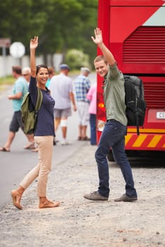 Couple, happy and wave for bus, travel and backpack for adventure, journey or transportation on street. Man, woman and smile outdoor in portrait with vehicle for road trip for vacation in Costa Rica.