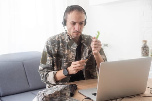 Portrait of young army soldier with a laptop. High quality photo