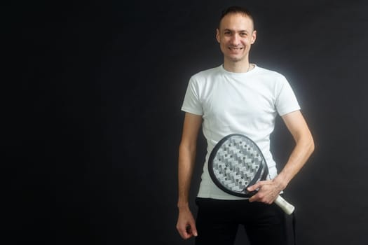 Man ready for paddle tennis serve in studio shot. High quality photo